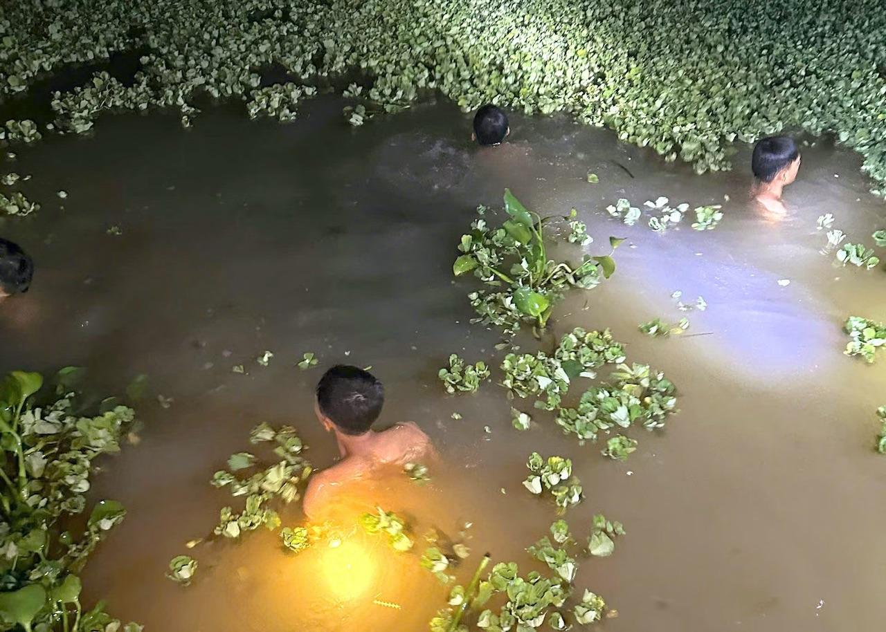 Lực lượng tìm kiếm đã tìm thấy thi thể cháu bé dưới 1 ao nước gần nhà. (Ảnh: Tiền Phong)