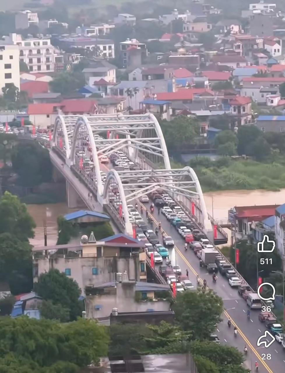 Ô tô đỗ 2 bên cầu để tránh lũ. (Ảnh: Thắm Nguyễn)