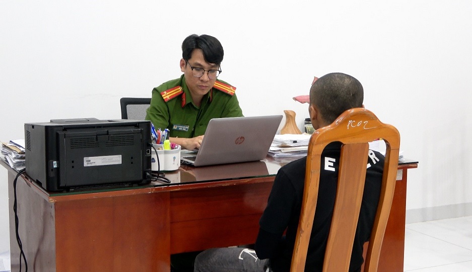 Điều tra viên Phòng Cảnh sát hình sự làm việc với Nguyễn Minh Thắng sau khi đối tượng đến đầu thú - Ảnh