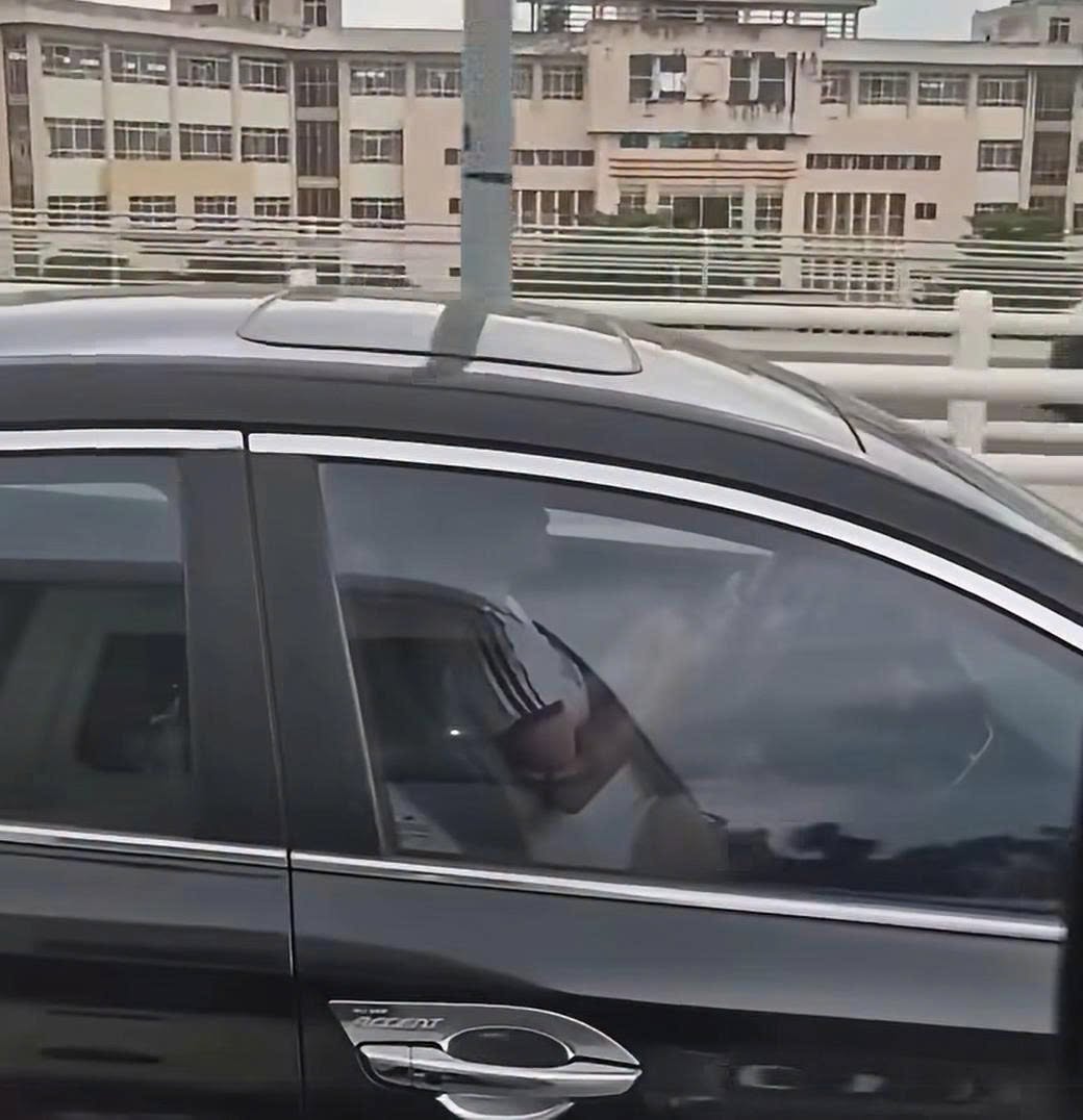 Nữ tài xế vừa điều khiển ô tô vừa sử dụng điện thoại. (Ảnh cắt từ clip)