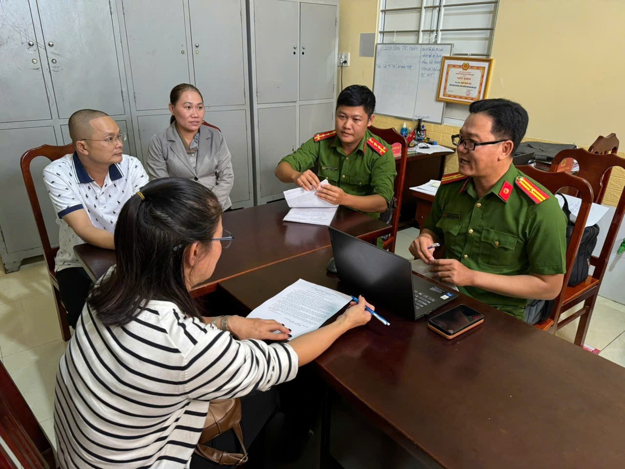 Công an phường Long Khánh phối hợp cùng Công an xã Phong Thạnh,Cà Mau hướng dẫn người dân thủ tục nhận lại số tiền - Ảnh: Công an Đồng Nai