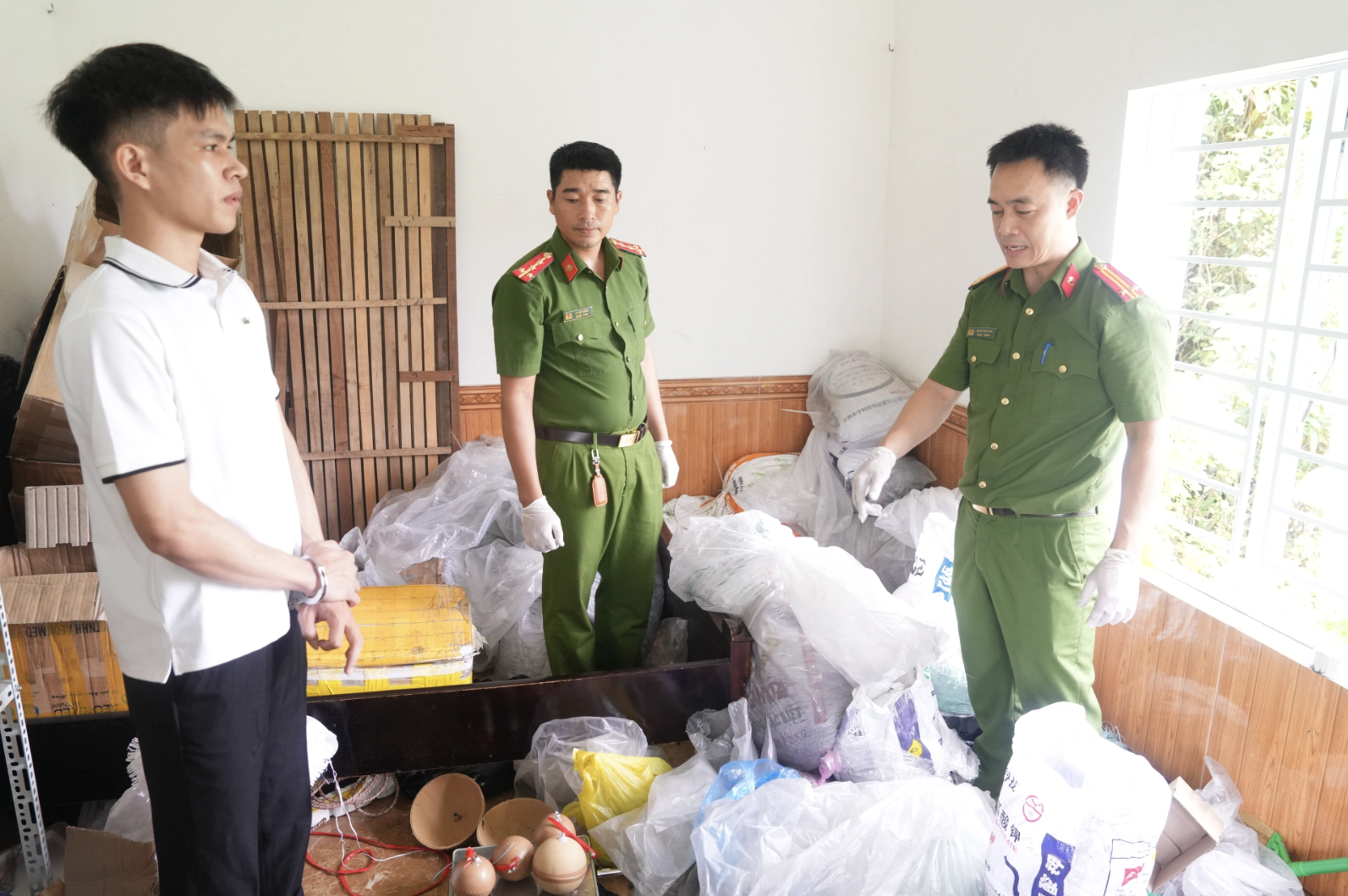 Công an phường Trường Vinh khám xét các thùng, bì tải chứa hóa chất do đối tượng Nguyễn Tiến Phi tàng trữ - Ảnh: Công an Nghệ An