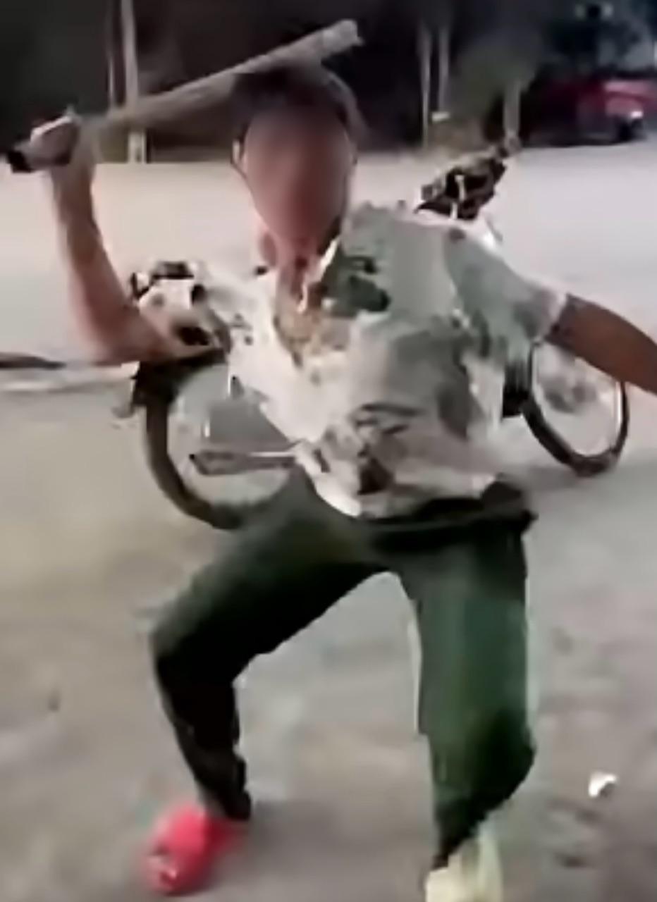 Sau khi lời qua tiếng lại, ông H. cầm điếu cày đuổi đánh nam thanh niên. (Ảnh: Cắt từ clip)