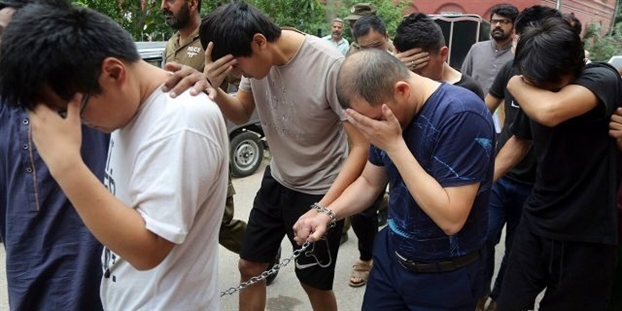 Các nghi phạm Trung Quốc bị cảnh sát dẫn giải ra tòa ở Lahore, Pakistan - Ảnh: AP