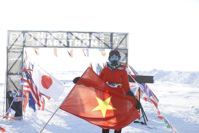 Tăng Nguyệt Minh cầm lá cờ Việt Nam khi hoàn thành Cuộc thi Marathon Bắc Cực 2018.