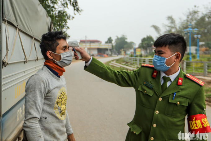 Một người dân được kiểm tra thân nhiệt khi đi qua chốt kiểm dịch. Hiện tại xã Sơn Lôi đã có 5 người bị nhiễm virus corona.