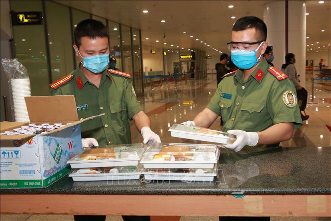 Lực lượng Công an cửa khẩu Cảng hàng không Quốc tế Nội Bài chuẩn bị đồ ăn tạm cho hành khách trong lúc chờ đi cách ly - Ảnh: TTXVN.