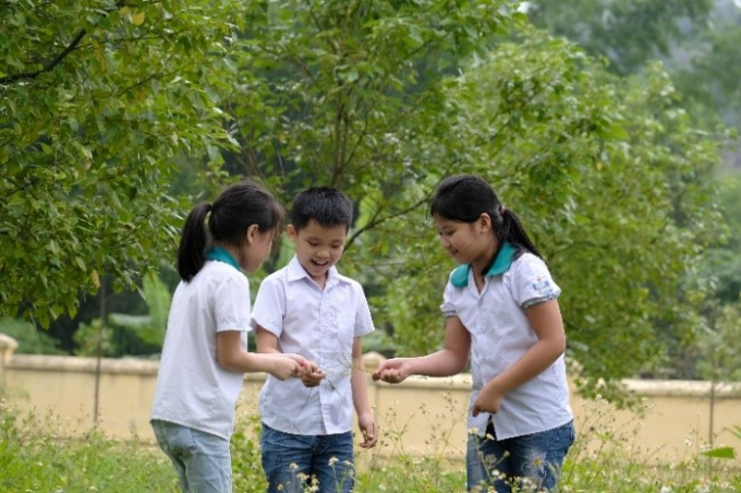 Các em học sinh đến tham quan và vui chơi bên những cây xanh do Quỹ 1 triệu cây xanh cho Việt Nam trồng tặng tại khu di tích lịch sử Nà Tu, Bắc Kạn.