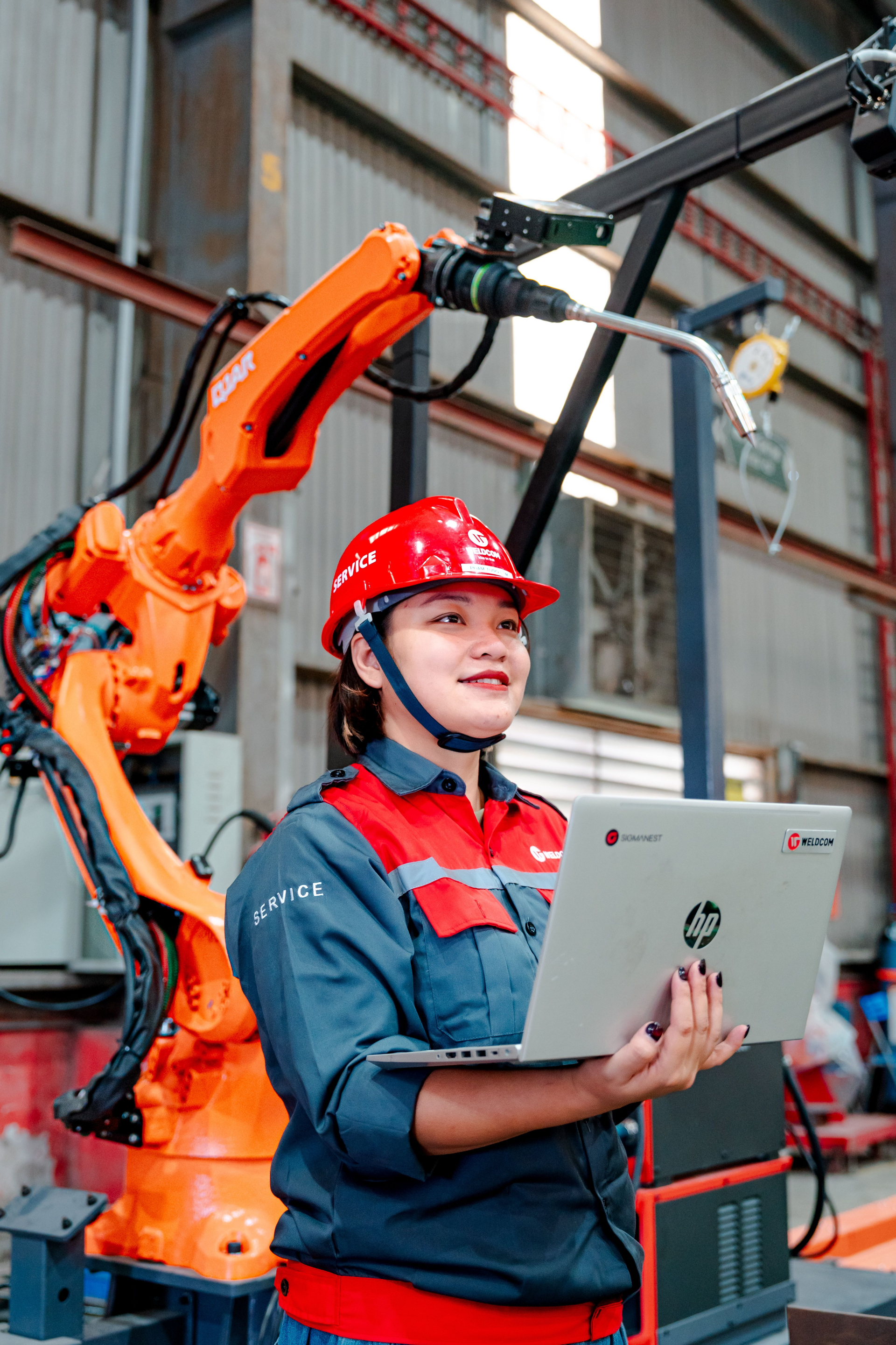 Một nữ kỹ sư làm việc cùng hệ thống robot trong nhà máy tại Việt Nam. Đào tạo ở các ngành khoa học và công nghệ chiến lược có thể dẫn người học tới những vị trí nghề nghiệp ngày càng gắn với tự động hóa và công nghệ cao. Ảnh minh họa tại Việt Nam: Hoang NC/Pexels.