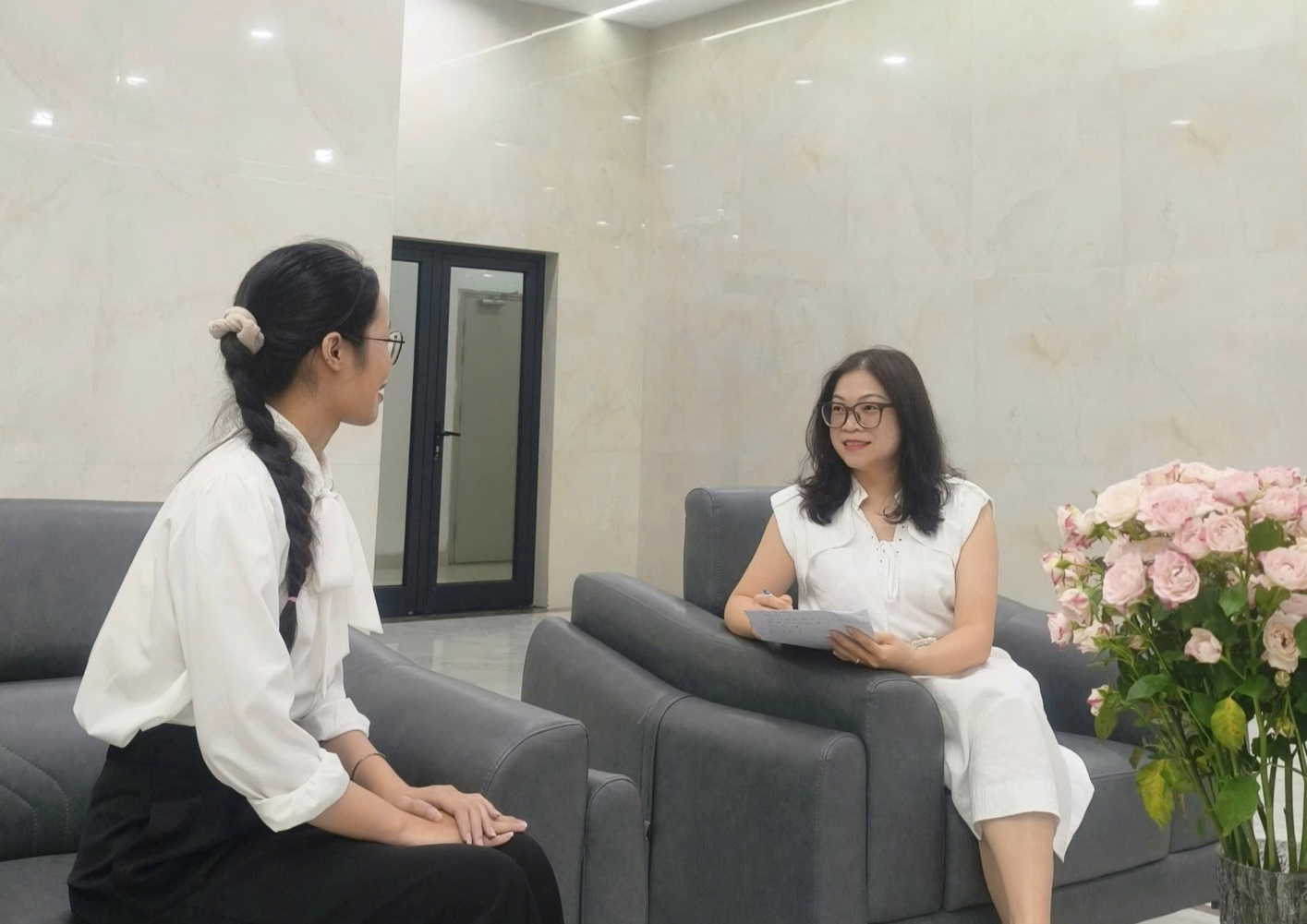 ThS Lê Thị Liễu Hạnh (bên phải, áo trắng, đeo kính, cầm tài liệu) trao đổi với một phụ nữ tại phường Yên Hòa trong đợt khảo sát. Ảnh: Viện Nghiên cứu Con người, Gia đình và Giới.