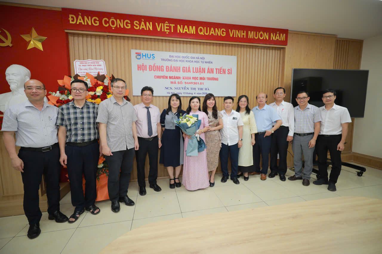 NCS. Nguyễn Thị Thu Hà, đứng giữa cầm hoa, cùng Hội đồng đánh giá luận án và các đại biểu ngày 13/4/2026. Ảnh: Viện Địa lý nhân văn và Phát triển bền vững.