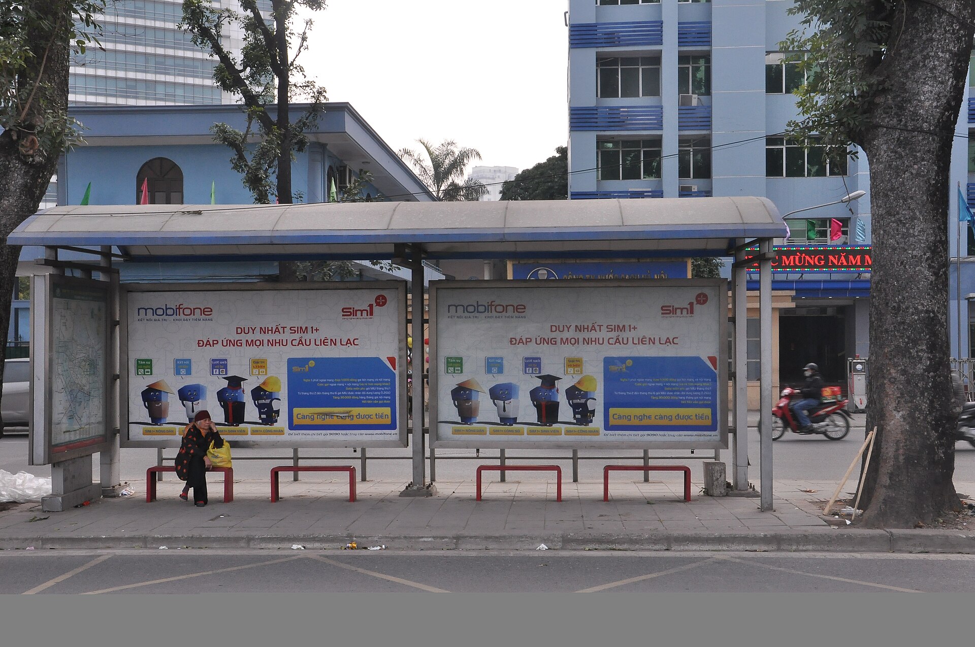 Một phụ nữ lớn tuổi chờ xe buýt tại Hà Nội năm 2018. Khả năng tiếp cận giao thông còn phụ thuộc vào trải nghiệm trước khi lên phương tiện. Ảnh: CedricNN/Wikimedia Commons, CC BY-SA 4.0.