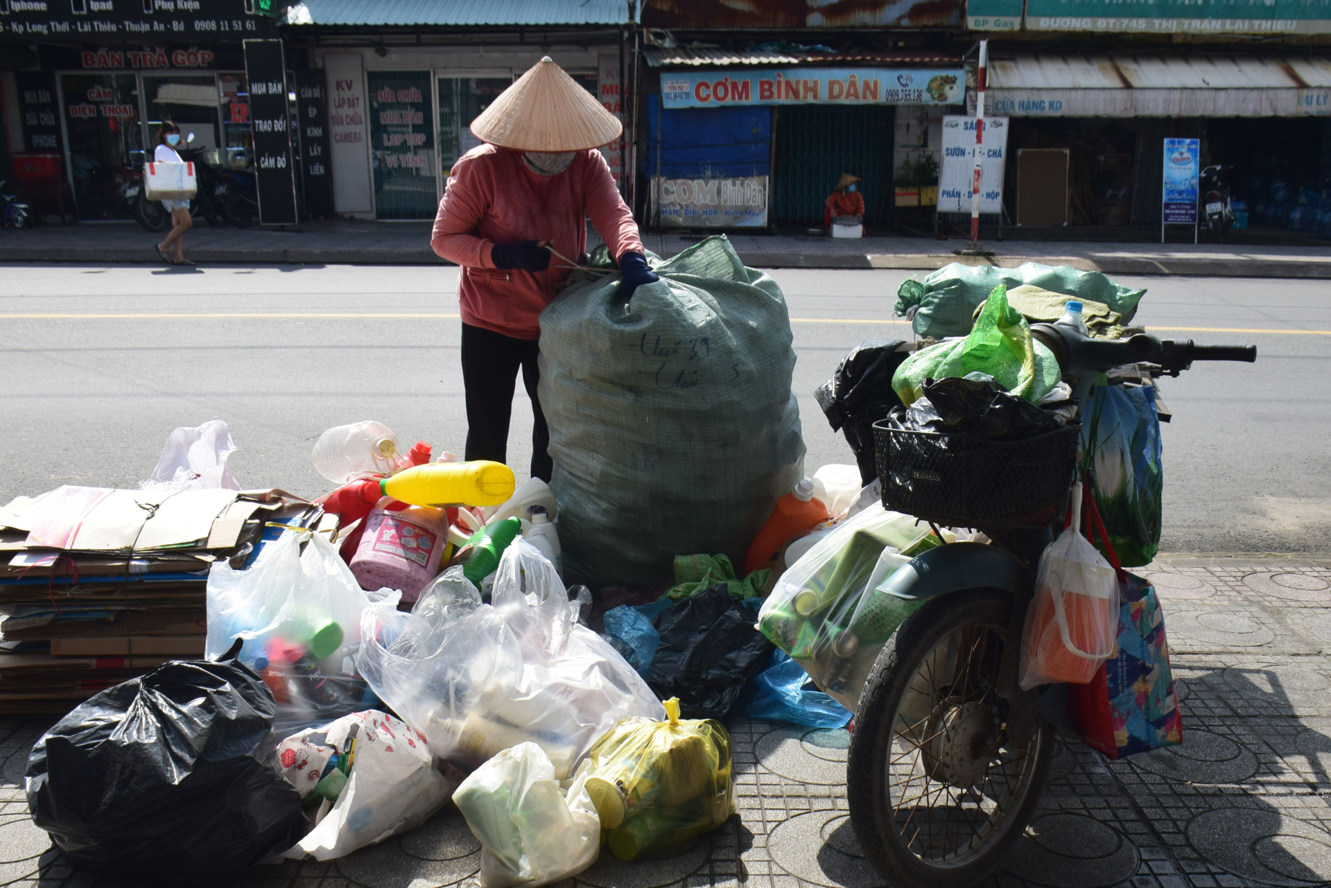 Một người bán hàng rong sắp xếp vật liệu có thể tái chế tại Thuận An, Bình Dương. Kinh tế tuần hoàn tạo ra nhiều công việc từ phân loại, thu gom đến tái sử dụng. Ảnh: Vyvan BÙI VY VÂN/Pexels.
