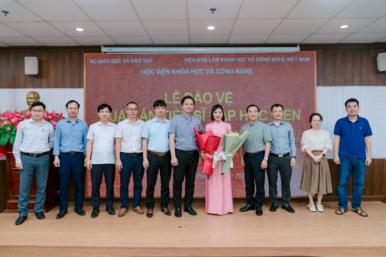 Nguyễn Thị Thu Hòa (áo dài hồng, chính giữa) cùng Hội đồng và tập thể hướng dẫn sau buổi bảo vệ luận án. Ảnh: Viện Khoa học vật liệu.