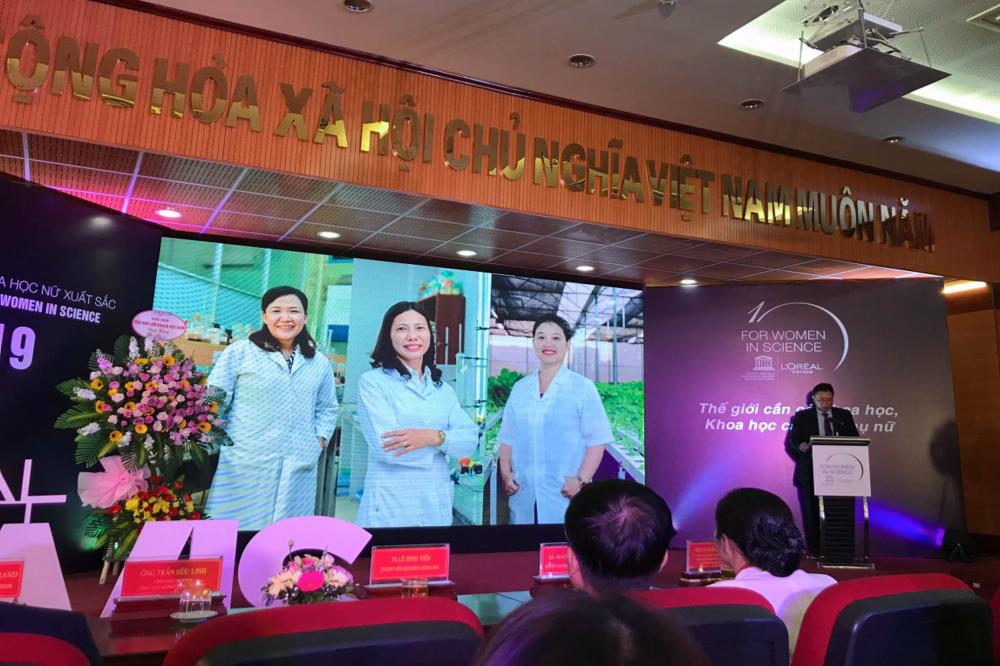 Hình ảnh TS Phạm Thị Thu Hà trong hoạt động giới thiệu nghiên cứu khoa học năm 2019. Trên màn hình phía sau có hình bà tại khu thực nghiệm cây trồng. Ảnh: TDTU.