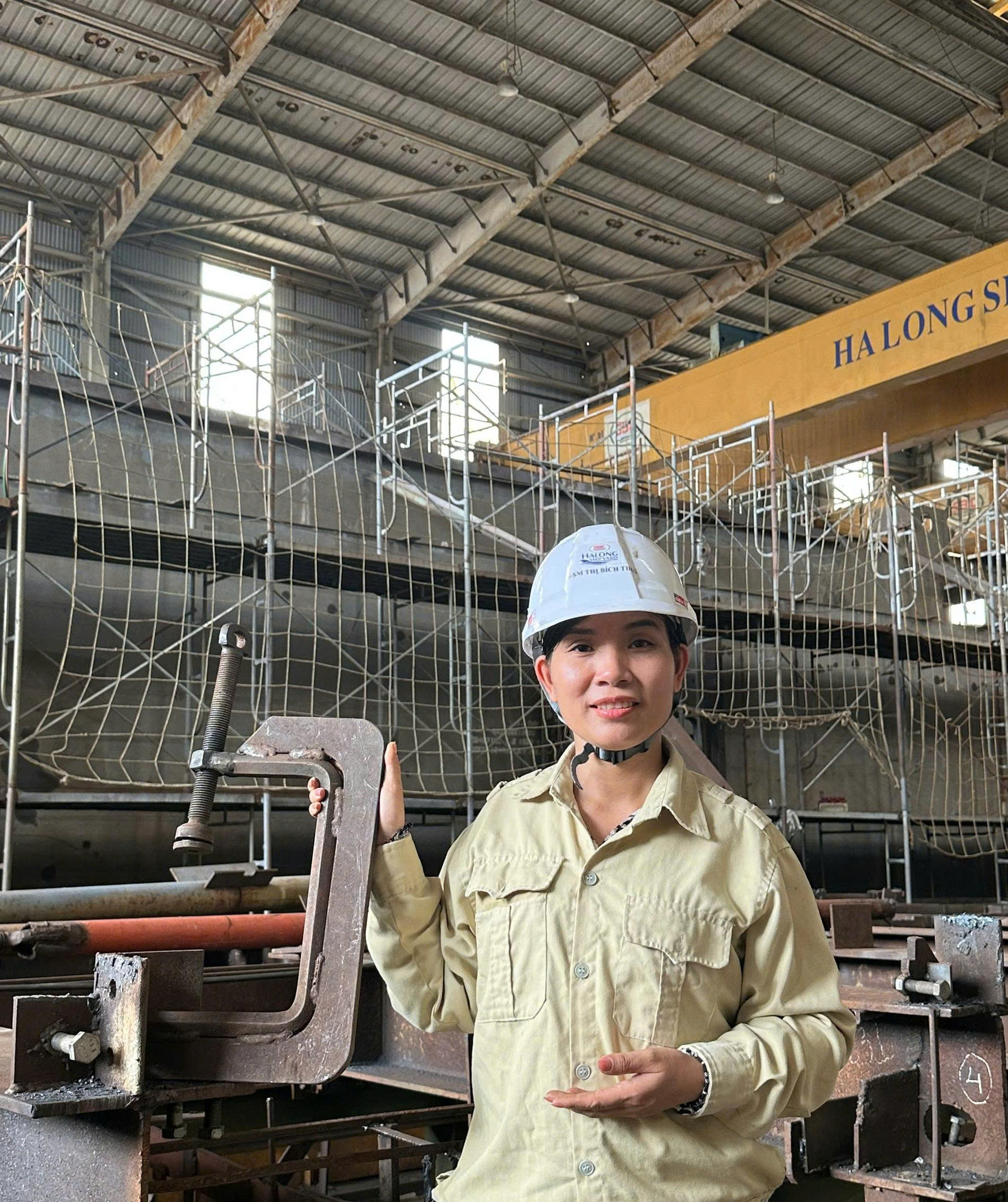 Kỹ sư Phạm Thị Bích Thủy tại xưởng, cầm một bộ vam kẹp cơ khí dùng trong công việc đóng tàu. Ảnh: SBIC.