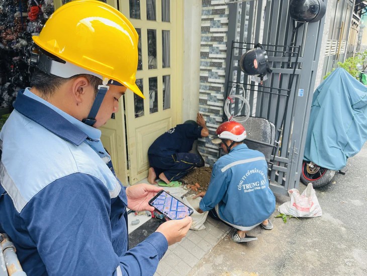 Nhân viên Cấp nước Trung An sử dụng bản đồ GIS trên thiết bị di động khi thực hiện công việc tại hiện trường. Ảnh: Lê Phan/Tuổi Trẻ.
