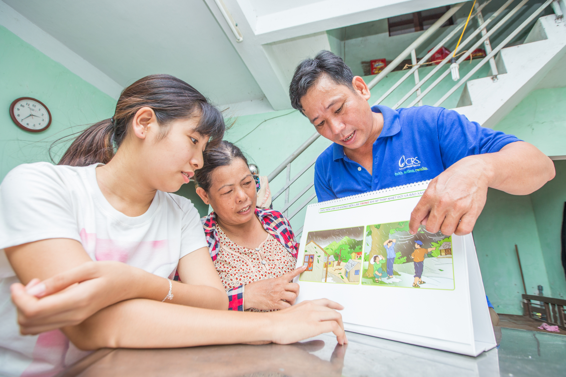 Cán bộ địa phương hướng dẫn phụ nữ các kỹ năng chuẩn bị ứng phó với lũ, bão tại Việt Nam.