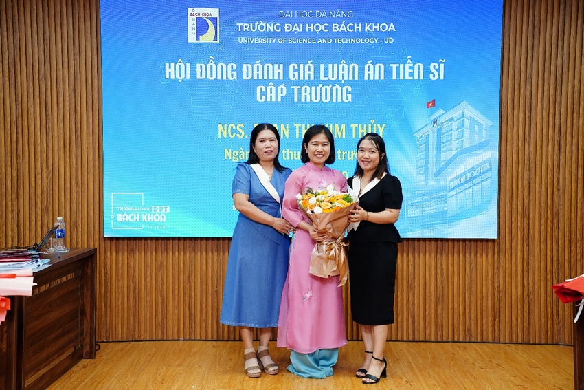 NCS. Phan Thị Kim Thủy, áo dài hồng, chụp ảnh lưu niệm sau buổi bảo vệ luận án cấp Trường. Ảnh: Trung tâm Học liệu và Truyền thông, Trường Đại học Bách khoa - Đại học Đà Nẵng.