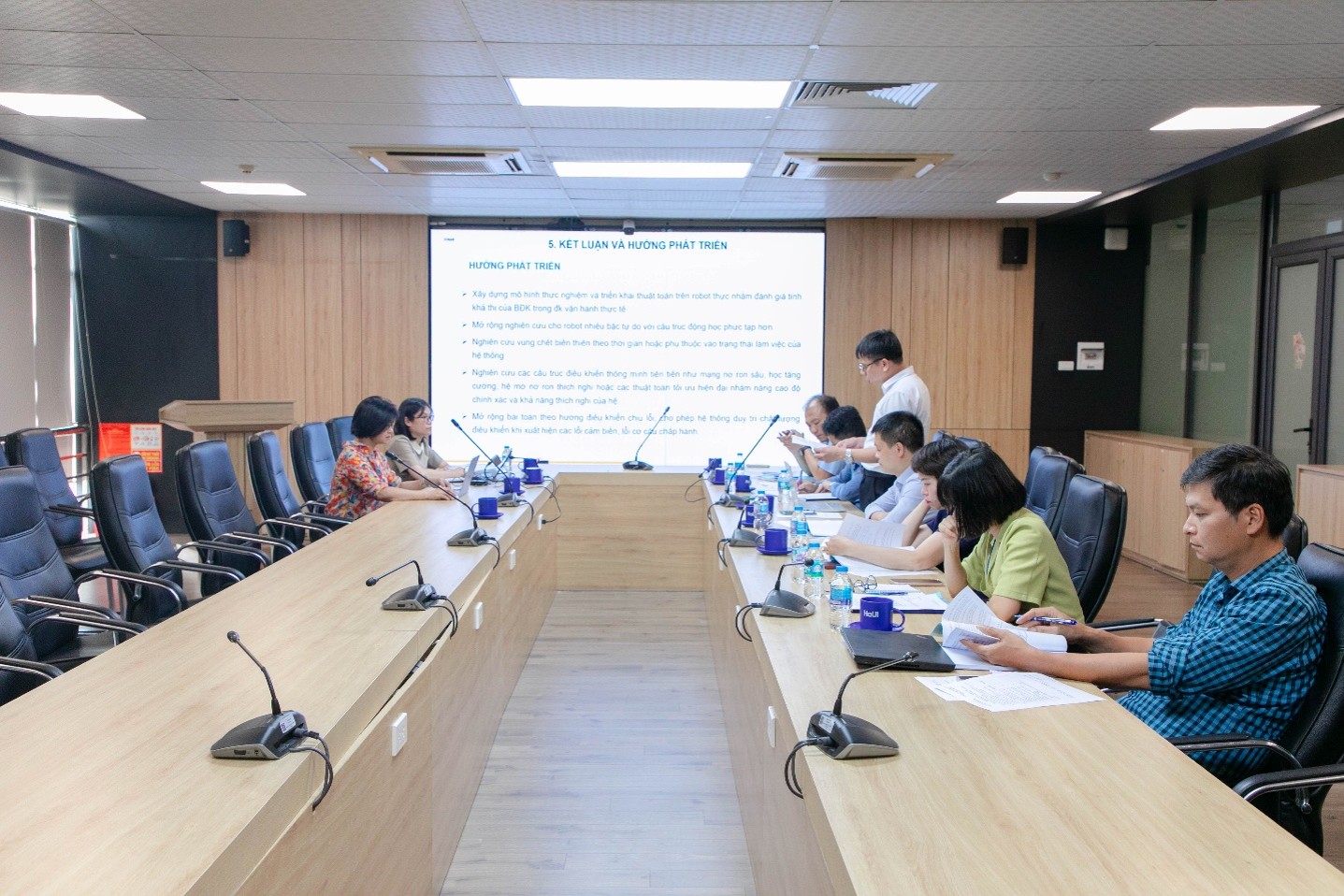 Hội đồng nghiệm thu trao đổi với nhóm thực hiện nhiệm vụ về kết quả thiết kế và mô phỏng bộ điều khiển cho robot công nghiệp. Ảnh: Đại học Công nghiệp Hà Nội.