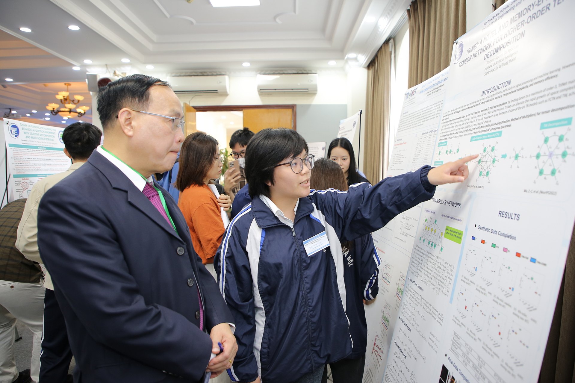 Sinh viên Nguyễn Thị Ngọc Lan trình bày poster TriNet tại Hội nghị Sinh viên nghiên cứu khoa học Trường Đại học Công nghệ năm 2026. Ảnh: Trường Đại học Công nghệ, Đại học Quốc gia Hà Nội.