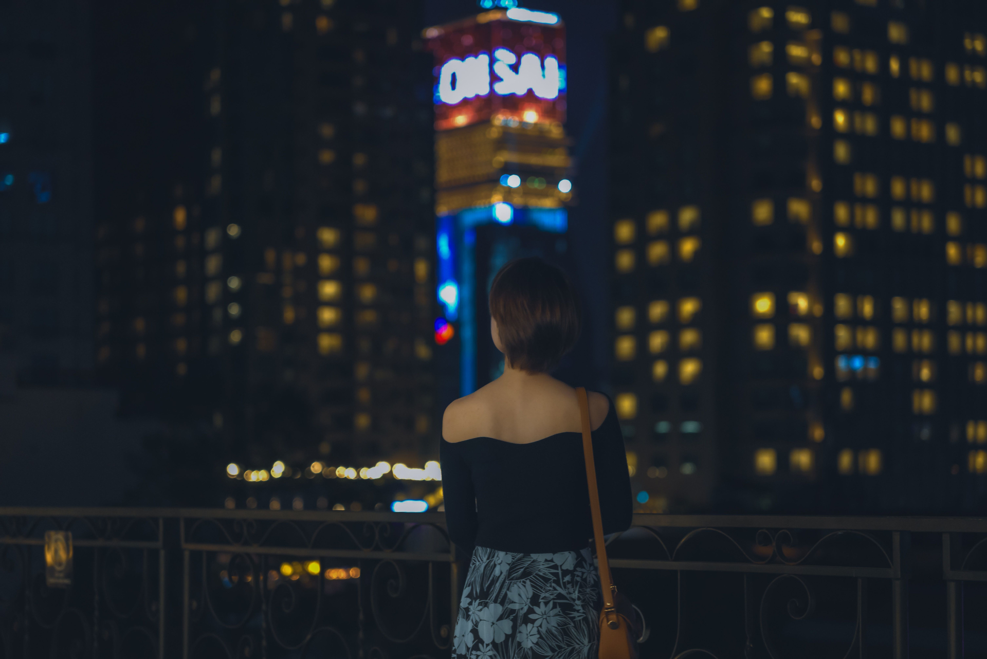 Một phụ nữ nhìn về khu trung tâm TP.HCM vào ban đêm. Nghiên cứu mới đặt vấn đề trải nghiệm tại điểm đến có thể chịu tác động đồng thời của nhiều bản sắc xã hội. Ảnh minh họa. Ảnh: Vuong/Pexels.