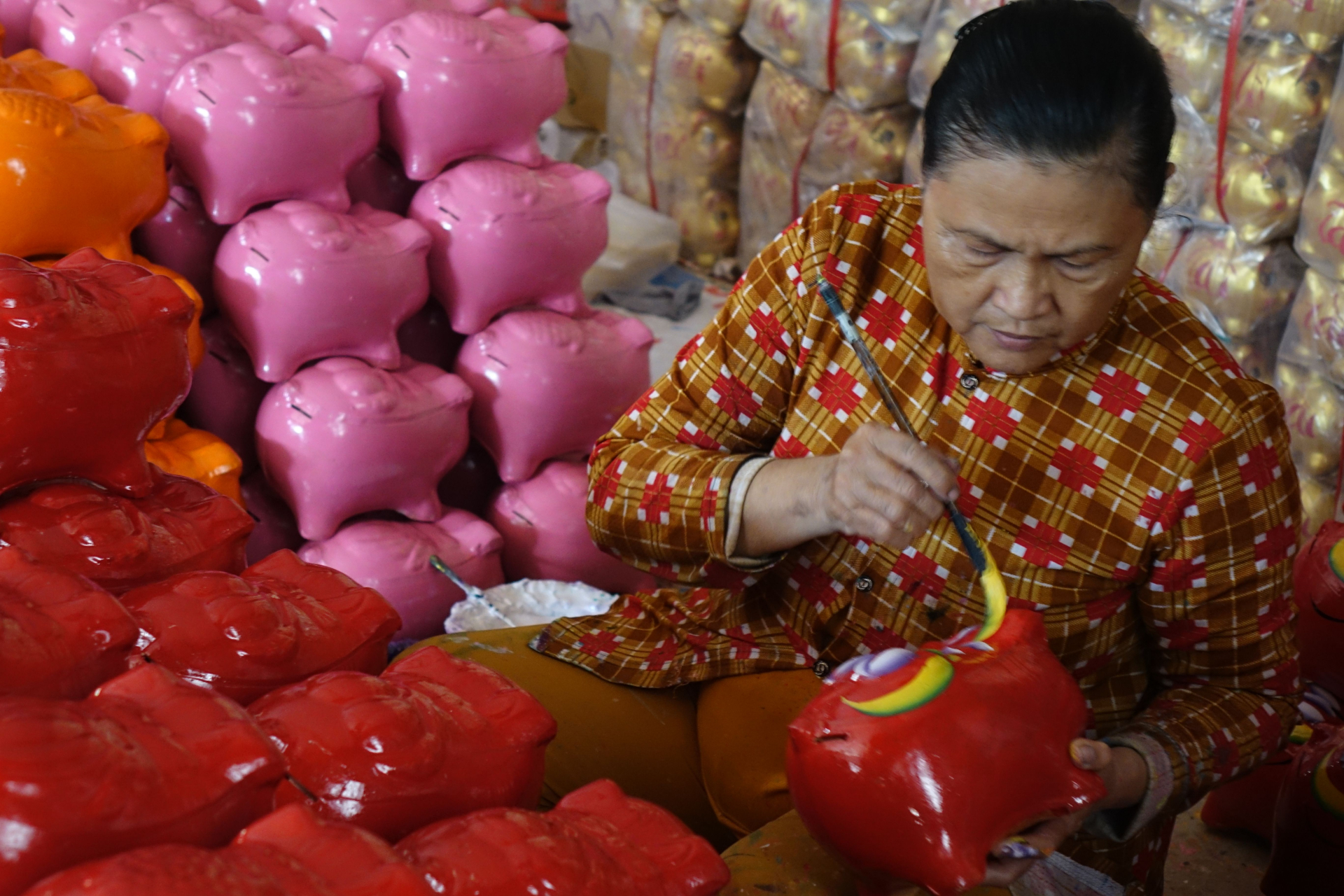 Người phụ nữ trang trí sản phẩm heo đất tại một cơ sở thủ công ở Việt Nam. Ảnh minh họa hoạt động nghề nghiệp. Ảnh: Vy Van Bui/Pexels.