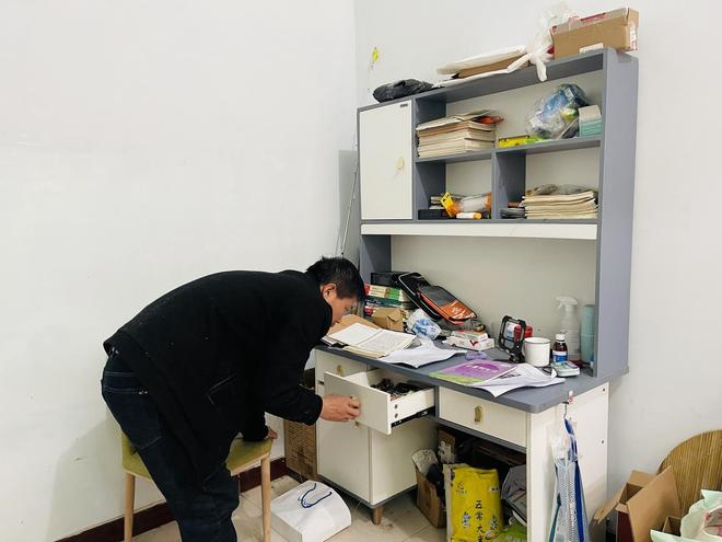Người cha đang dọn dẹp bàn học của con