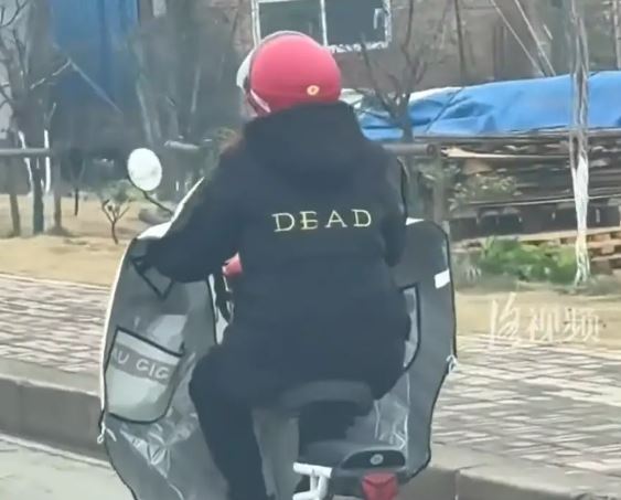 Cụ bà mặc áo có chữ Dead