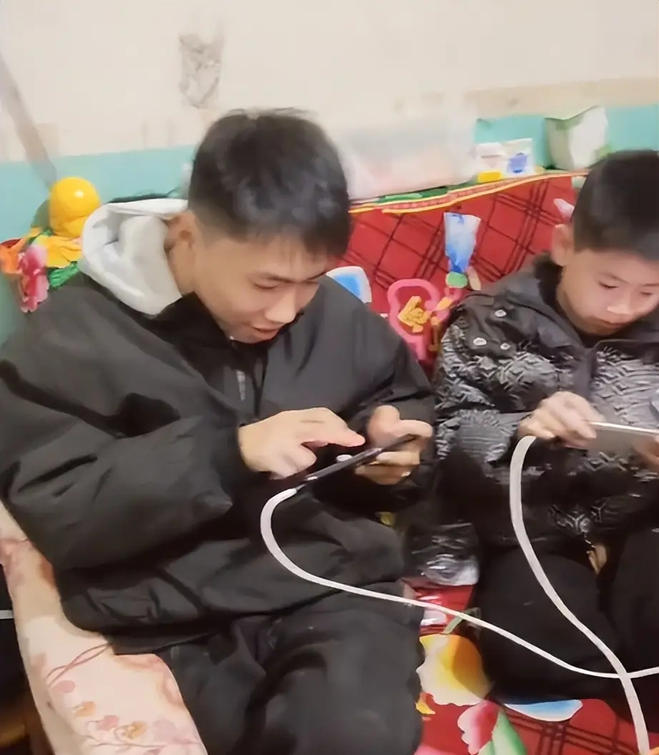 Trong đoạn video, một hàng dài các cậu bé ngồi trên chiếc sofa cũ, mỗi người cầm một chiếc điện thoại chơi game, tất cả đều xoay ngang màn hình.