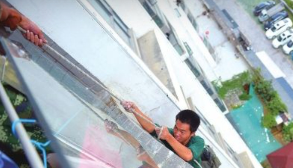 Sau một lúc bị treo ngoài tòa nhà, anh Lưu đã được mọi người giải cứu