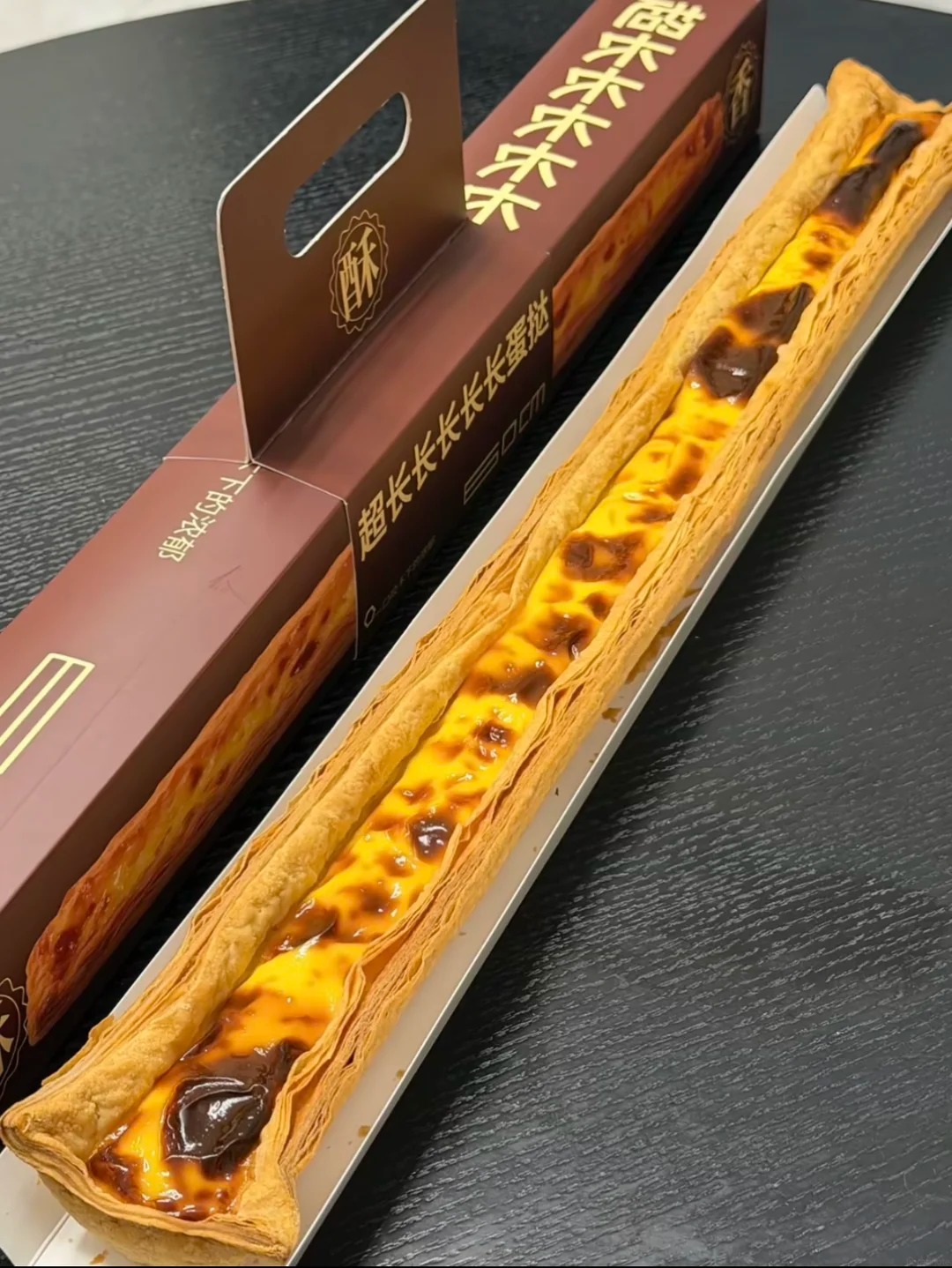Để giữ được dáng dài 60 cm, vỏ bánh phải làm dày hơn hẳn tart thường. Ảnh: Xiaohongshu