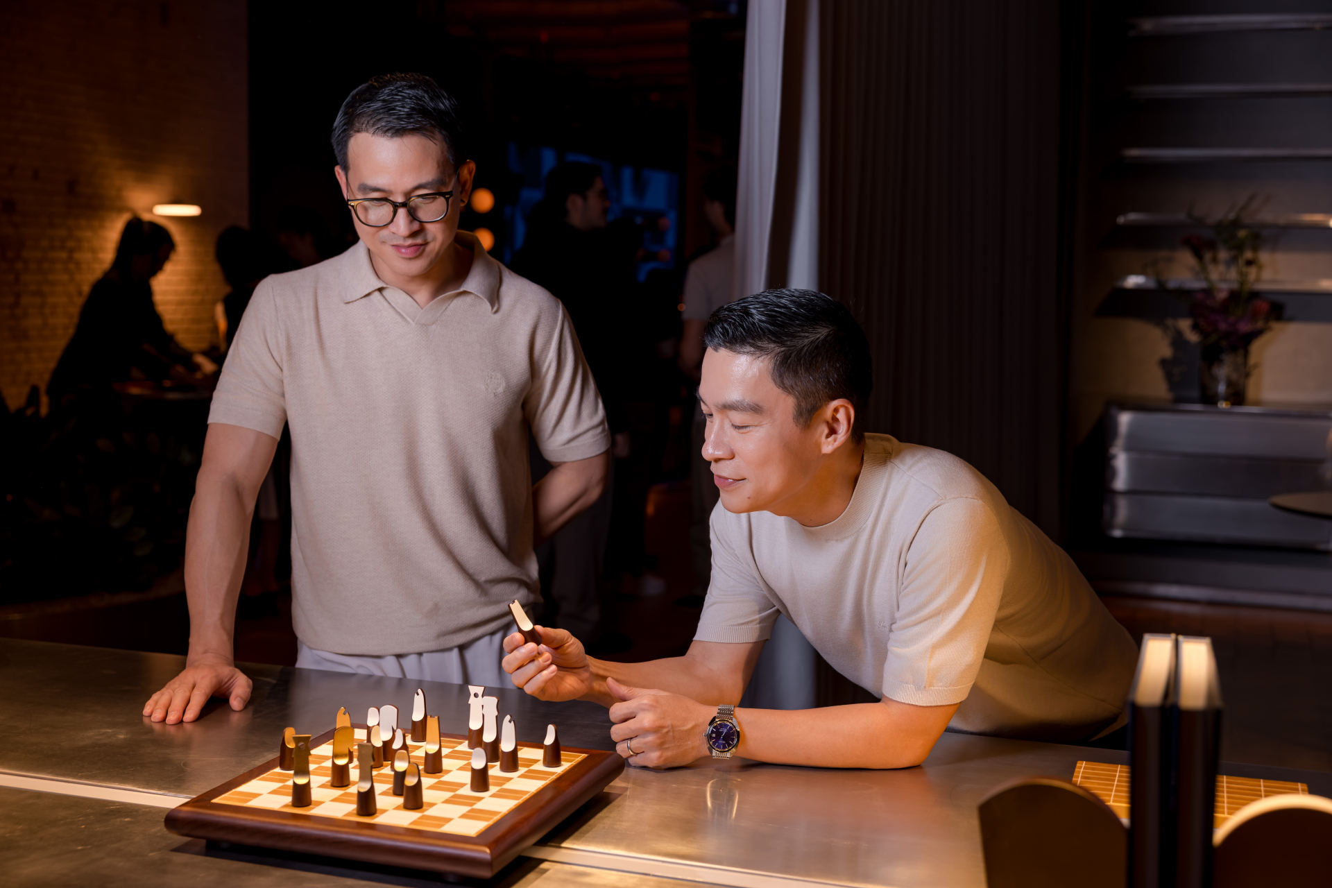 Cặp đôi Adrian Anh Tuấn và Sơn Đoàn bên bộ cờ vua sơn mài tông vàng. Ảnh: Hanoia