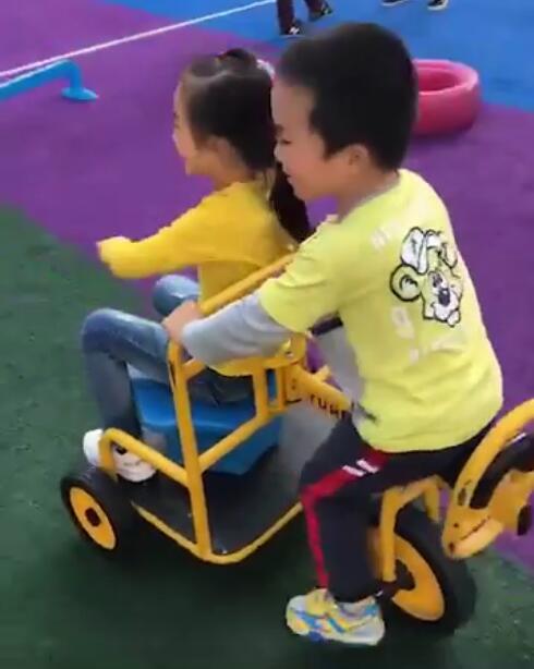 Ngay sau đó, cô giáo gửi thêm một video khác. Lần này, cậu bé đang lái chiếc xe đồ chơi trong trường mầm non, phía trước còn chở một bạn nữ, khiến cô bé vui vẻ vô cùng.