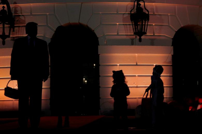 Tổng thống Mỹ D.Trump đang xách giỏ kẹo đến cho trẻ em trước thềm lễ Halloween ở Nhà trắng ngày 28/10/ Ảnh: Tom Brenner