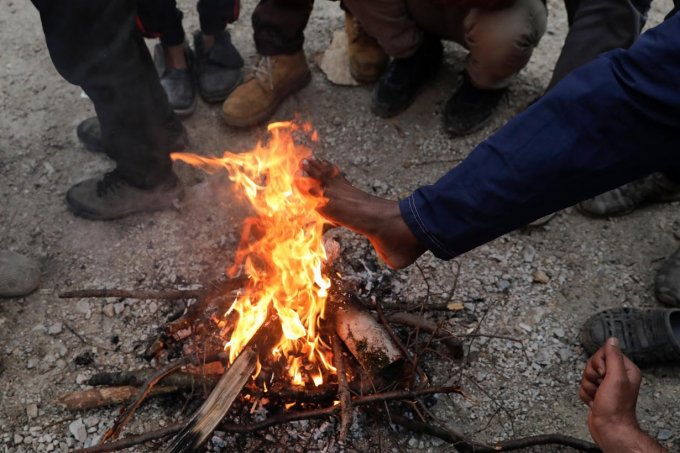 Người nhập cư đang sưởi ấm từ đống lửa ở trại Vucjak. Họ sống nhờ đồ ăn từ các tổ chức từ thiện. Thịt ở đây là một thứ hiếm hoi.  
