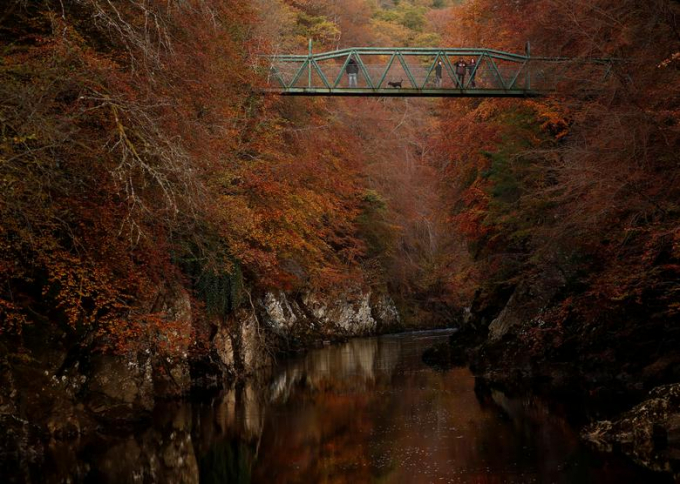 Du khách đang đi qua cây cầu bắc qua sông Garry, Pitlochry, Scotland/Russell Cheyne