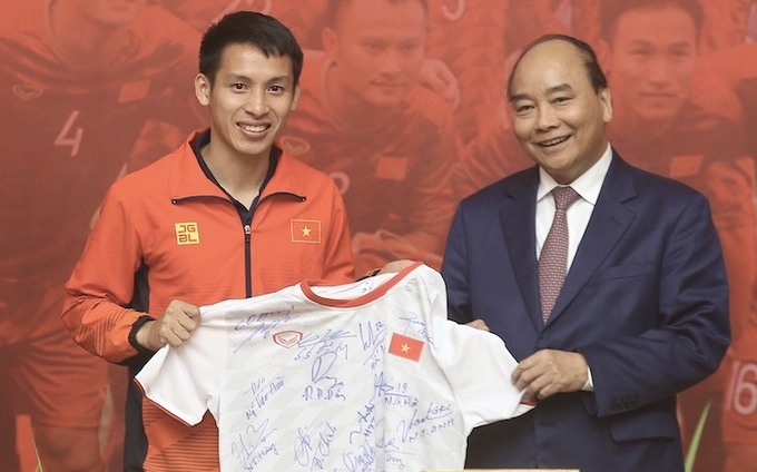 Trung vệ Nguyễn Hùng Dũng tặng Thủ tướng chiếc áo đấu có chữ ký toàn đội/ Ảnh VNE
