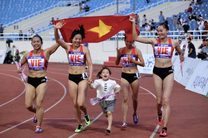 VĐV điền kinh Nguyễn Thị Huyền ăn mừng nắm tay con gái, ăn mừng chiếc huy chươngvàng cùng đồng đội/ Ảnh: Minh Đoàn