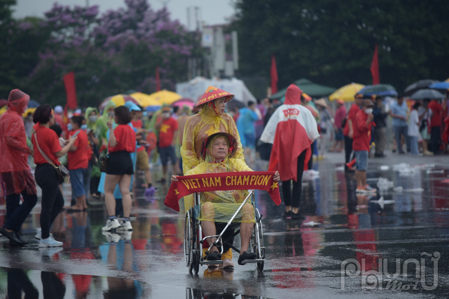 Một CĐC chân bị thương vẫn đội mưa đi xem đội tuyển thi đấu/ Ảnh: Hoàng Toàn