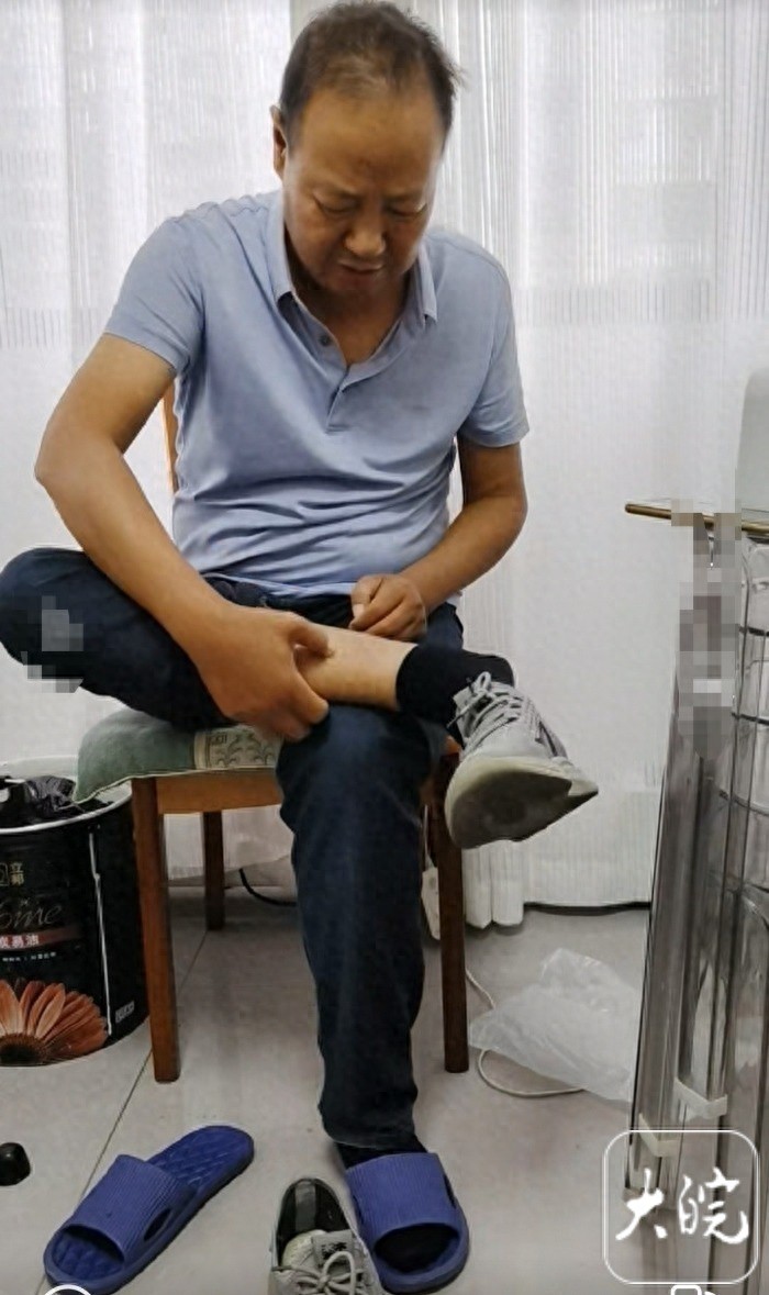 Đôi chân sưng phù vì bệnh tật khiến thầy Lý Kiện phải đi giày ngoại cỡ để đi dạy (Ảnh: Dawan News)