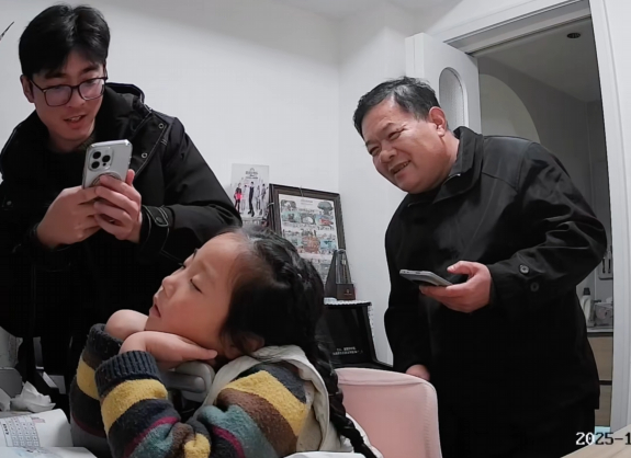 Người lớn trong nhà chia nhau ghi lại khoảnh khắc dễ thương của cô bé (Ảnh chụp màn hình)