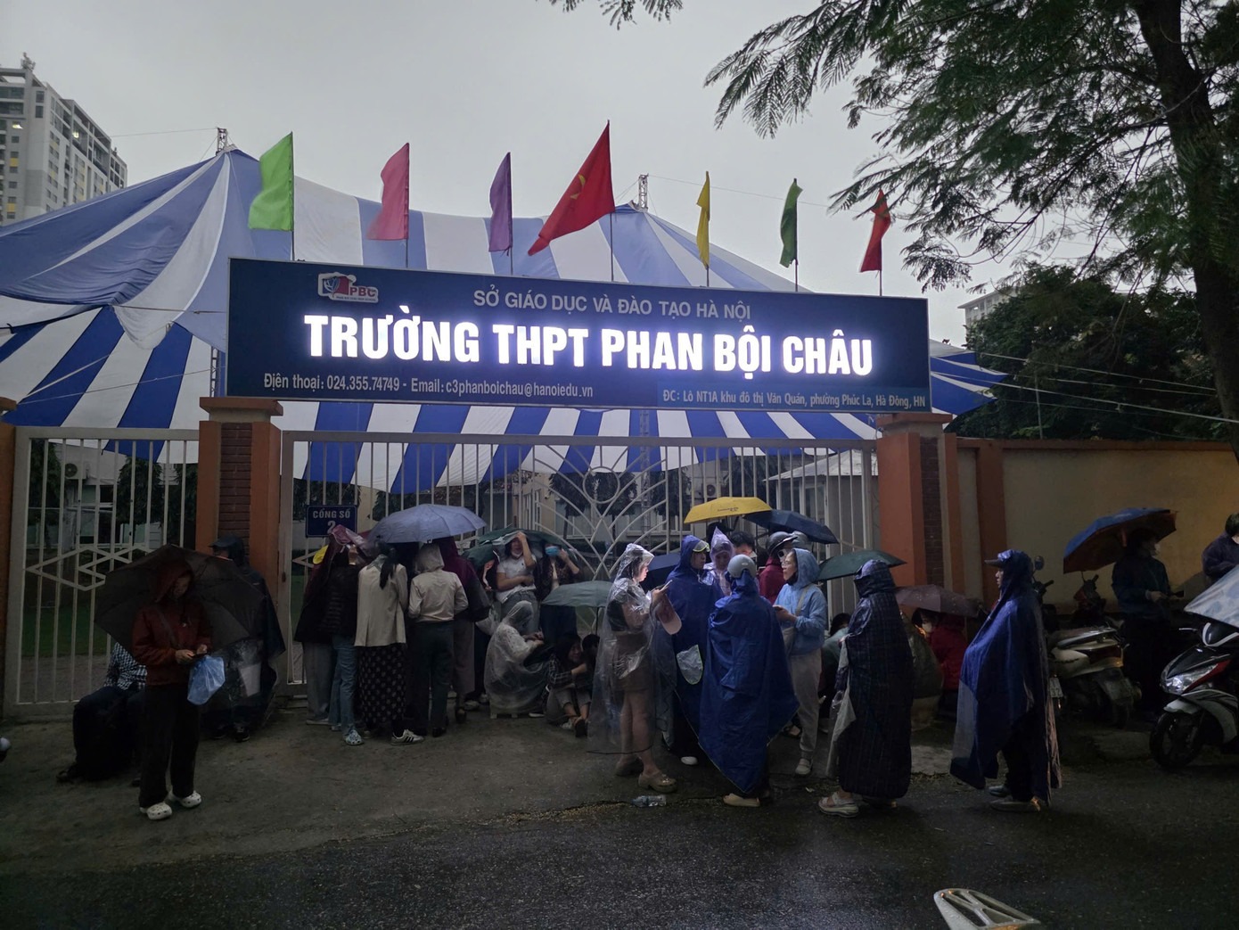 Cảnh tượng phụ huynh đội mưa xếp hàng nộp hồ sơ cho con tại trường THPT Phan Bội Châu (Hà Nội) gây xôn xao (Ảnh: Tiền Phong)