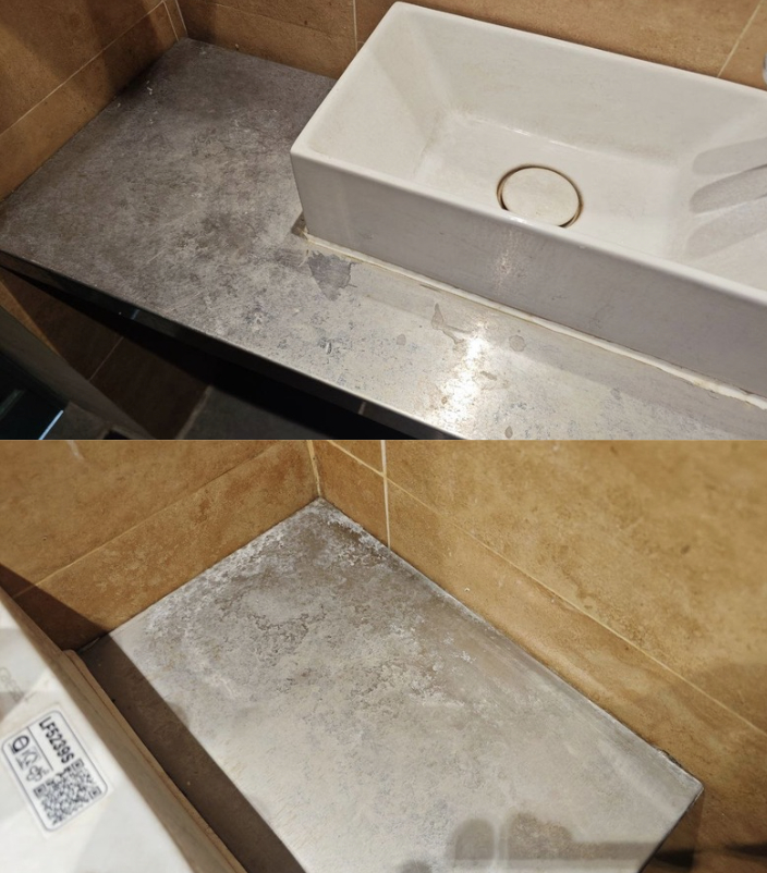 Bồn rửa tay và mặt bàn đá có nhiều vết trầy xước, bong tróc.