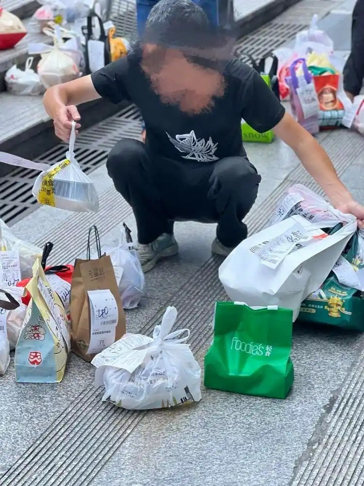 Một shipper giao hộ nhận hàng dưới chân tòa nhà và chuẩn bị giao cho khách