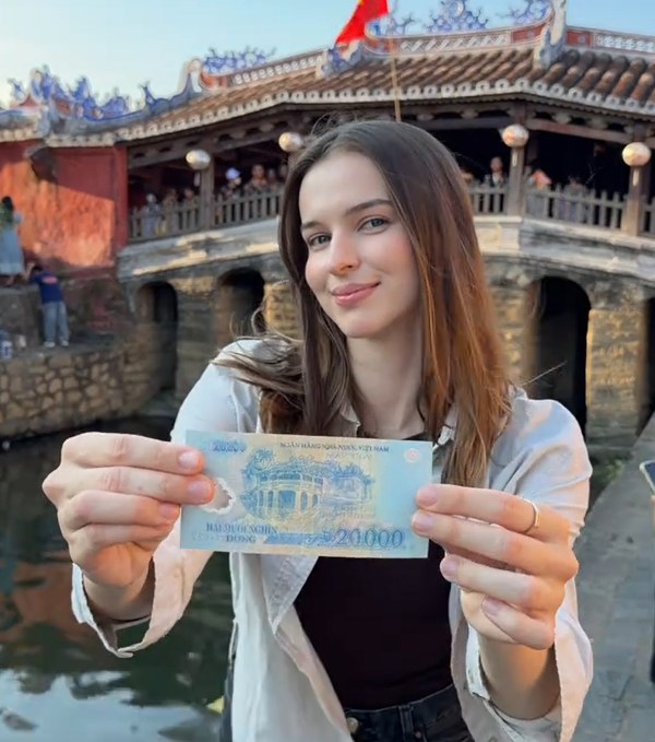 Iryna check-in tại Chùa Cầu (Hội An) cùng với tờ 20.000 đồng 