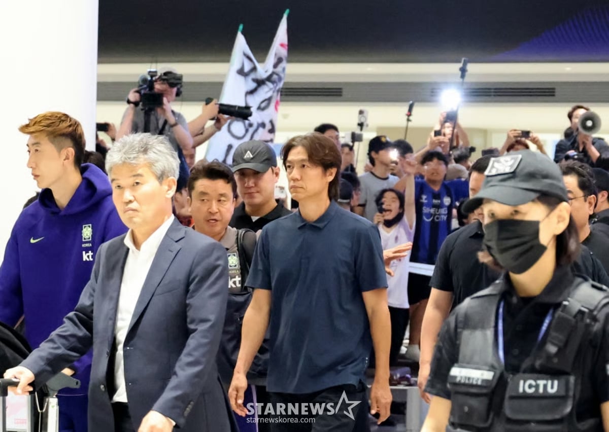 HLV Hong Myung-bo đi giữa tiếng la ó (Ảnh: StarNews)