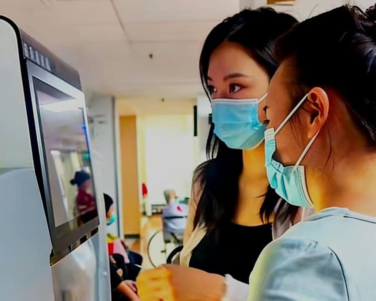 Zhao (bên trái) trong 1 lần đưa khách hàng đi khám bệnh