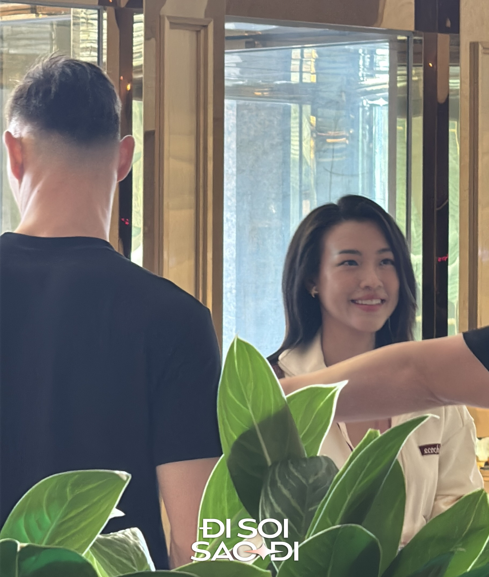 Hoàng Oanh đứng cùng Lê Giang Patrik trò chuyện với một trợ lý