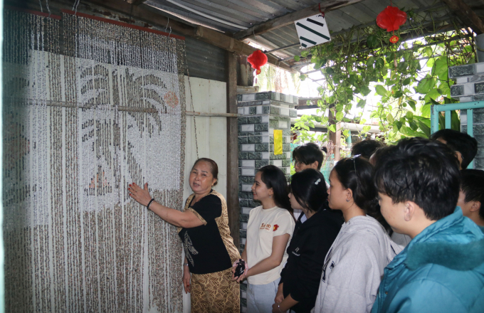 Đoàn sinh viên tham quan và lắng nghe người dân Bích Đầm nói về nghề làm mành óc